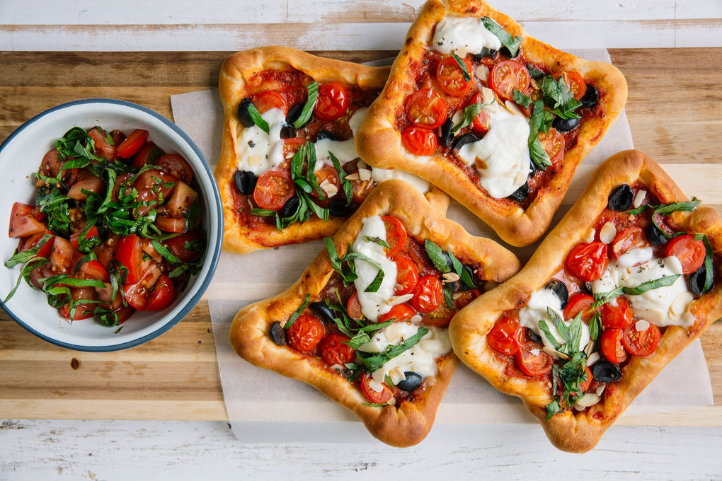 Mini-pizza's met mozzarella, basilicum, olijven en amandelen